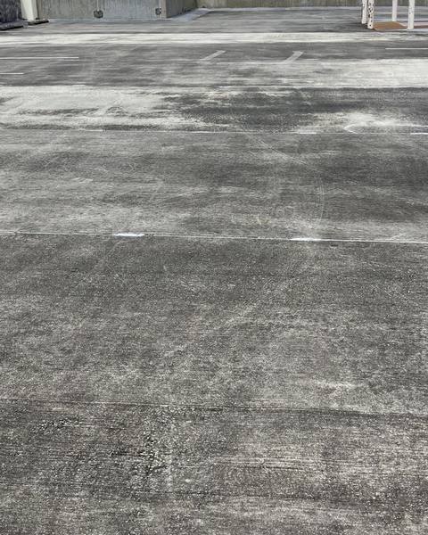 Parking garage top deck at Sarasota Memorial Hospital before pressure washing, dark and stained