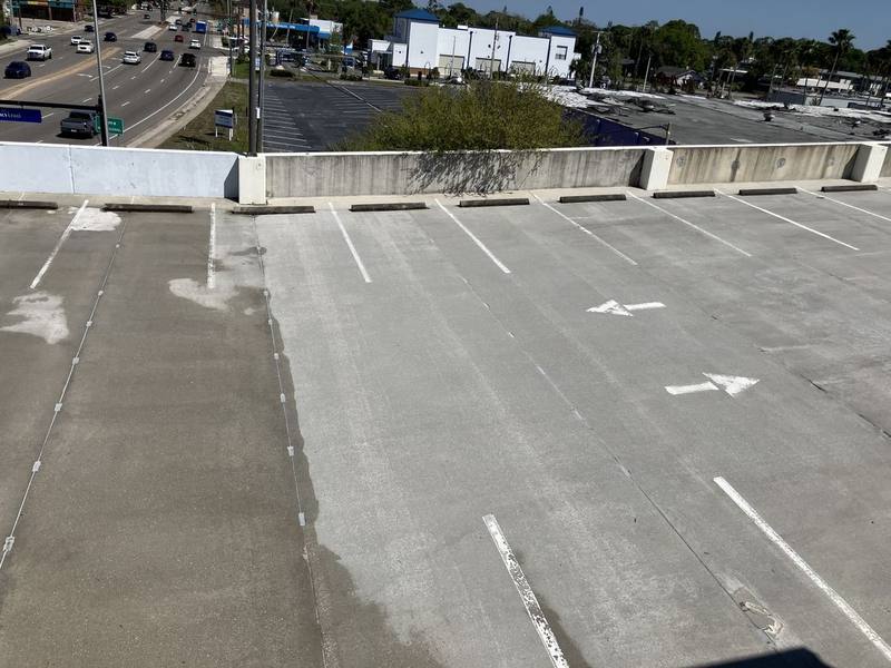 Garage lane with a dark uncleaned strip on the left and lighter cleaned concrete on the right